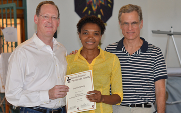 Paul Farmer (left) and Rob Kaplan, who congratulated Beatrice Romela for completing the Zanmi Lasante Leadership and Management Seminar in Cange, Haiti
