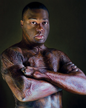 HIS BROTHERS’ KEEPER: In 2005, at age 21, Jelani stood for this Doug Auld portrait. Eight years earlier, Jelani and his two younger brothers had been caught in a fire that raged through their apartment. Jelani got his brothers to safety but then the flames forced him to the back of the dwelling.