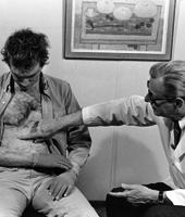 POINT OF INTEREST: John Burke indicates an area of a patient’s abdomen that had been severely burned but was then repaired using Burke’s artificial skin product.</br>Photo credit: Massachusetts General Hospital Archives