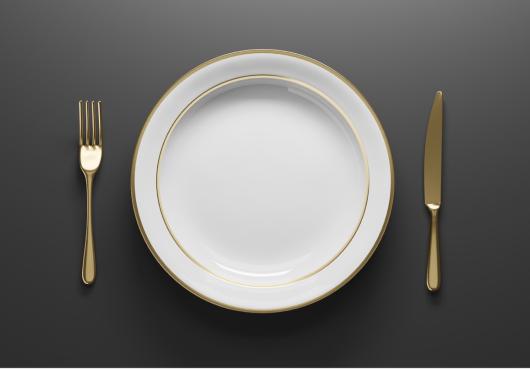 Photo from above of an empty plate with fork and knife