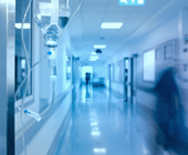 Hospital hallway with blurred figures and gurney
