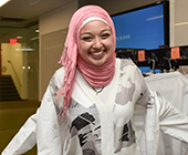 student putting on her white coat