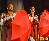 students dancing with red umbrellas
