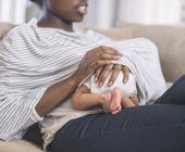 woman breastfeeding infant under a coverup