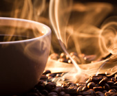 cup of steaming coffee and coffee beans