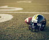 Photo of football and helmet on field