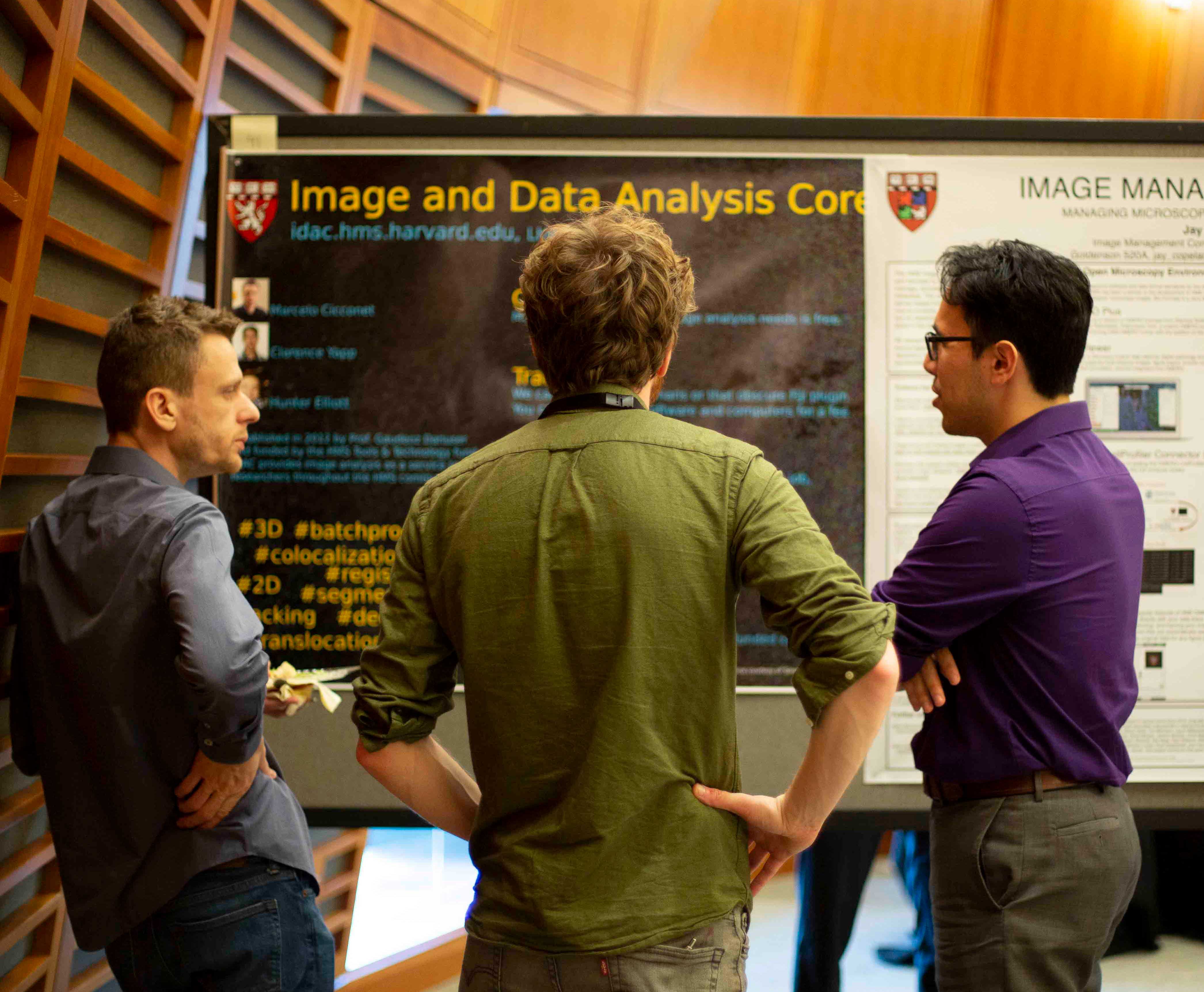3 students looking at a poster at the Cores poster showcase.