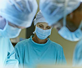 Photo of three surgeons in scrubs, 2 male, 1 female