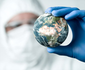 Photo of male doctor in mask holding globe in gloved hand