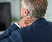 photo of back of man with gray hair holding neck tension