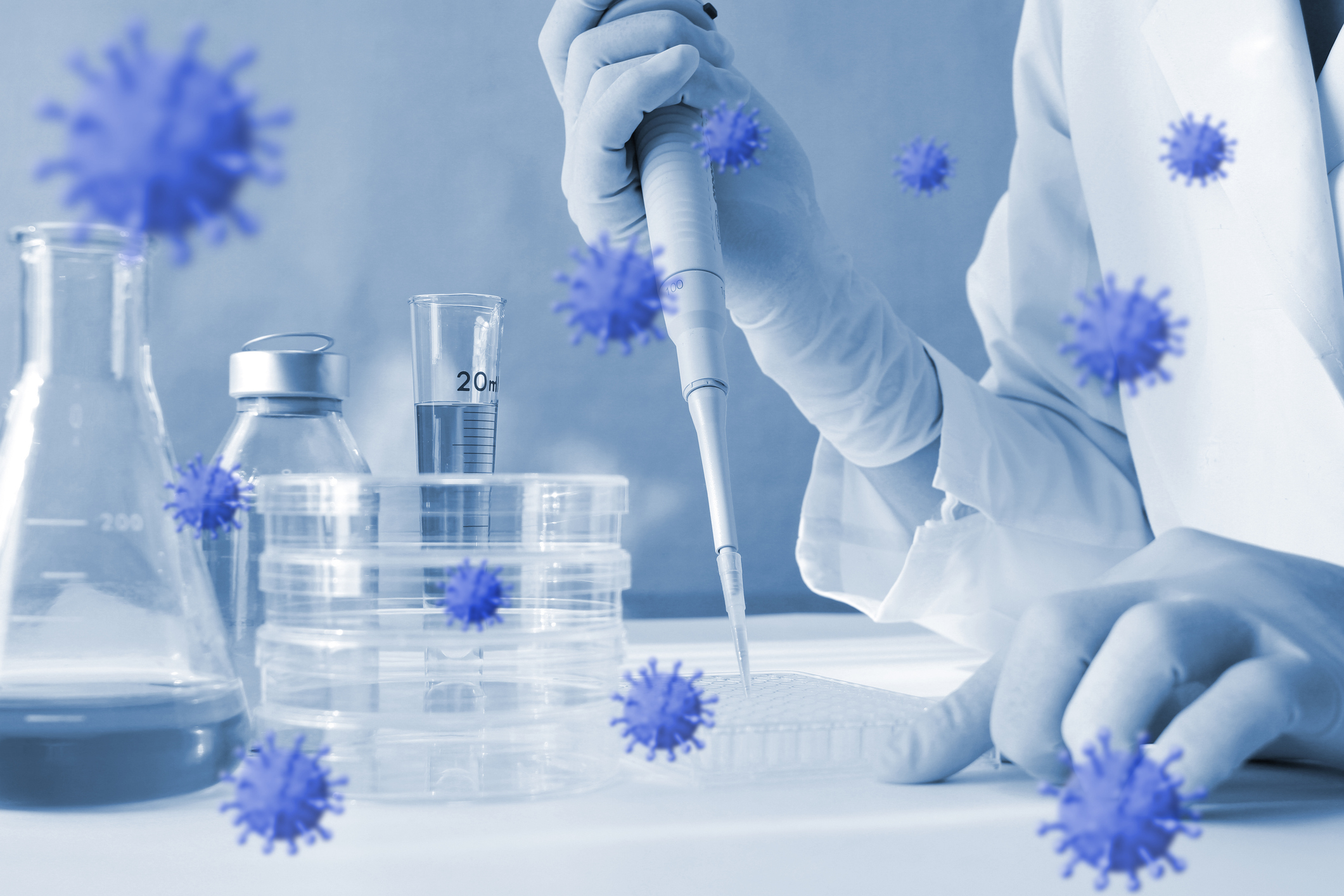 close up image of scientist in gloves and white coat with pipette and digital overlay of coronavirus