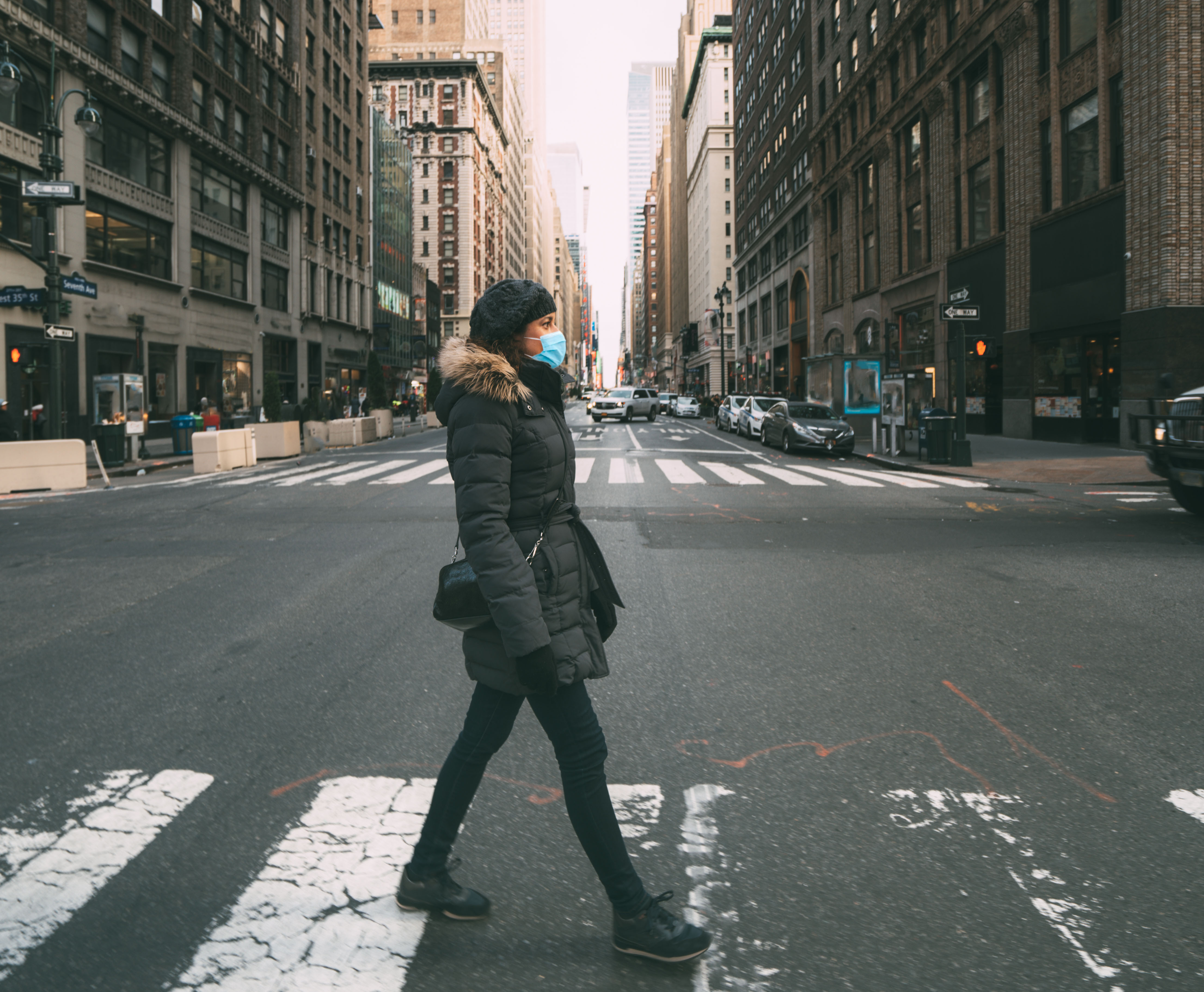 person crossing New York City street with mask on