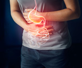 photo of man holding painful stomach with digital overlay of stomach and GI tract