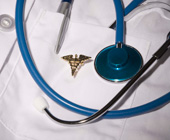 photo of stethoscope and rod of Aesculapius on white coat