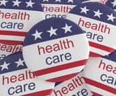 Multiple political buttons with U.S. flag and health care printed on them