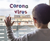 child looking out window with sticker on it that says coronavirus