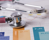 Stethoscope on paper with charts and graphs