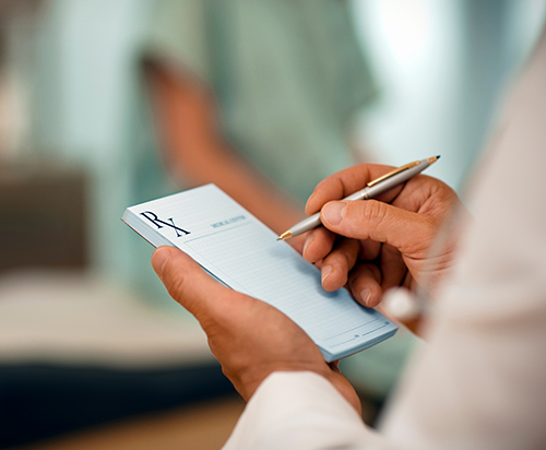 photo of man writing on prescription pad, cropped to hands