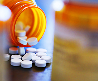 open prescription bottle and pills on a table