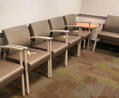 empty chairs in waiting room with tape x-marks for social distancing