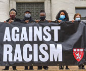 People holding a 'Stand Against Racism' banner at HMS 