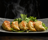 photo of chinese fried dumplings on a platter with steam rising off them