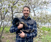 Photo of LaMarche in a NY city park holding his miniature poodle