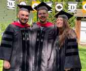 three grads in regalia on class day