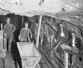 Old black and white photo of miners down in a mine