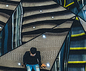 photo of unidentifiable person standing amidst a mosaic or mirrors