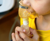 close up of child's face making an inhalation with a nebulizer