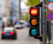 Photo of traffic signal on red, city street blurred out in background