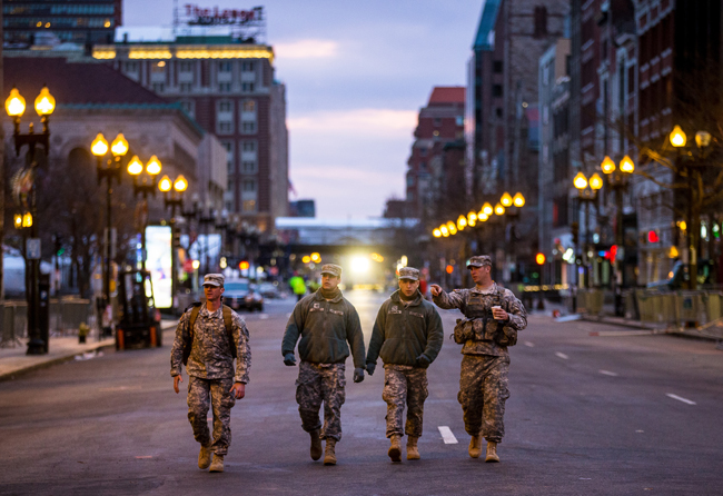 three members of the National Guard walk down the middle of Boston's Boylston Street