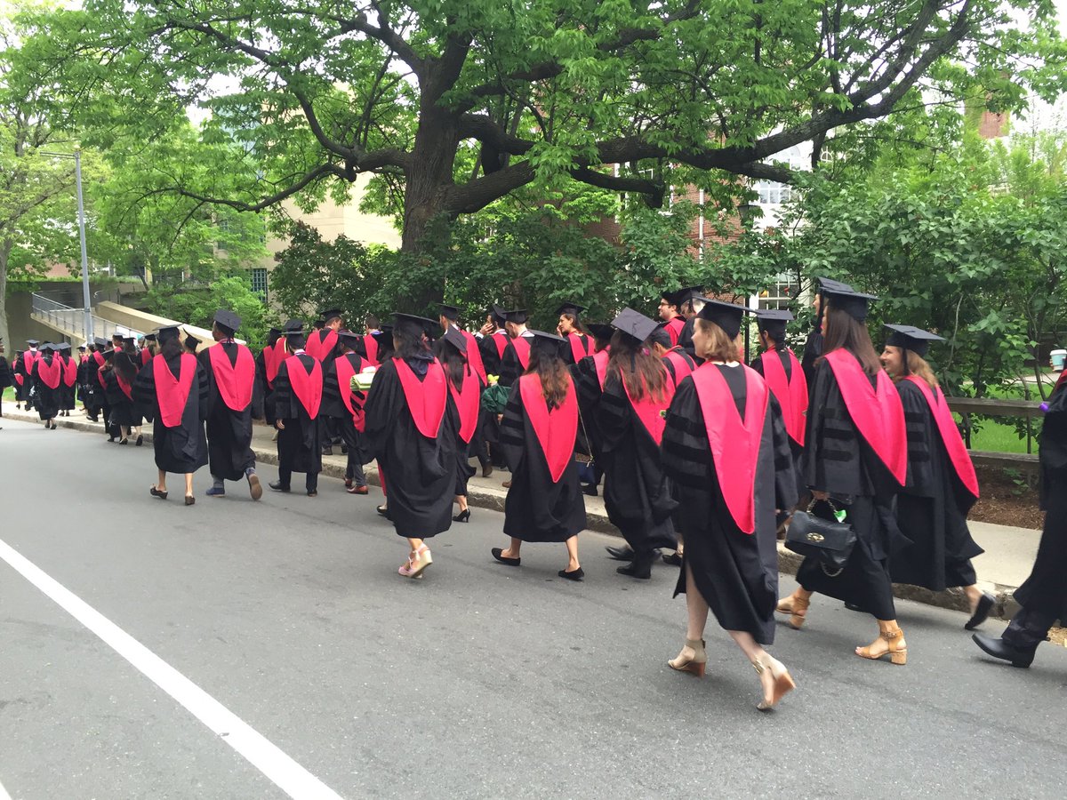 HMS MD grads walking in procession, in caps & gowns, from behind