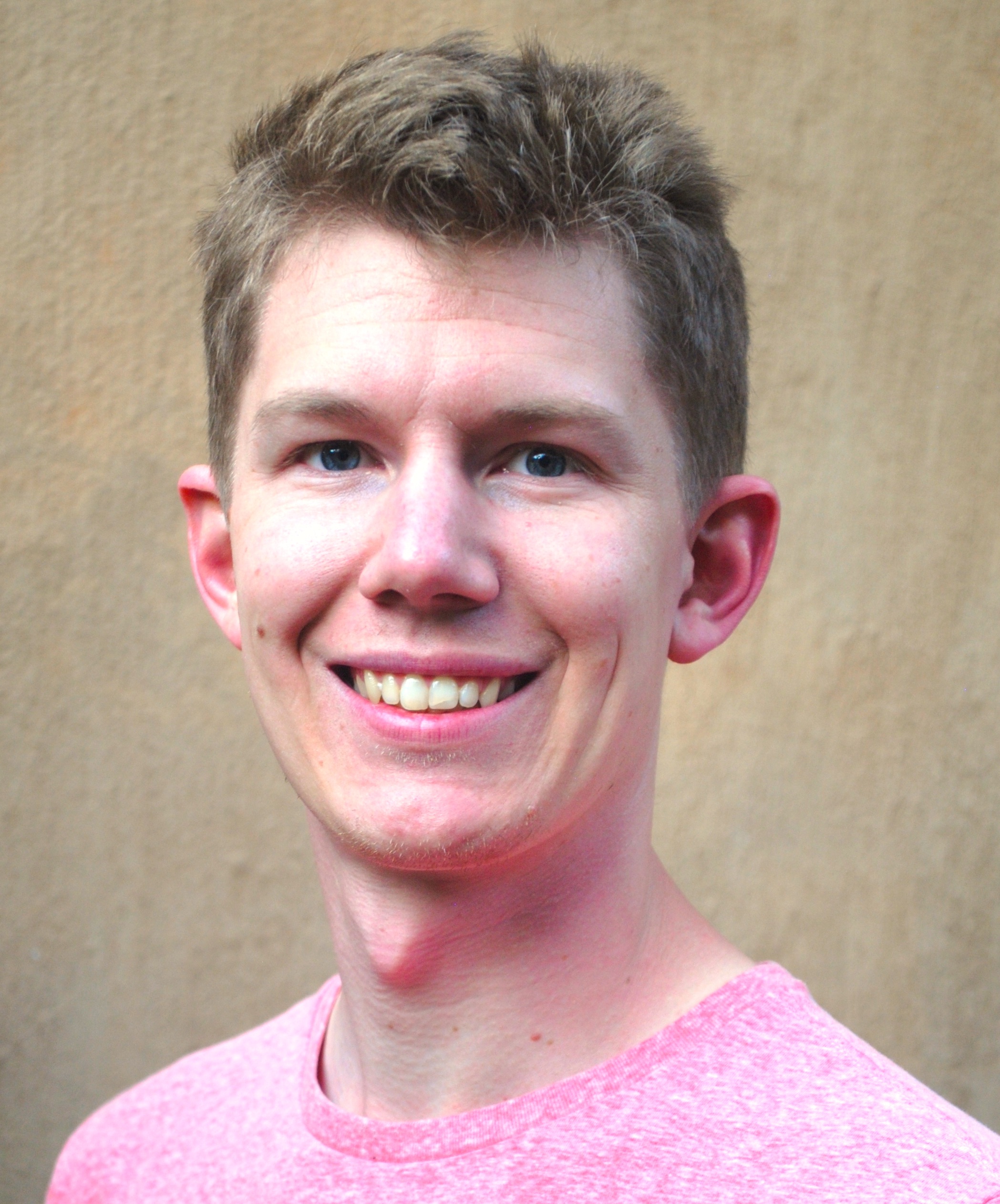 Head shot of smiling man in pink shirt