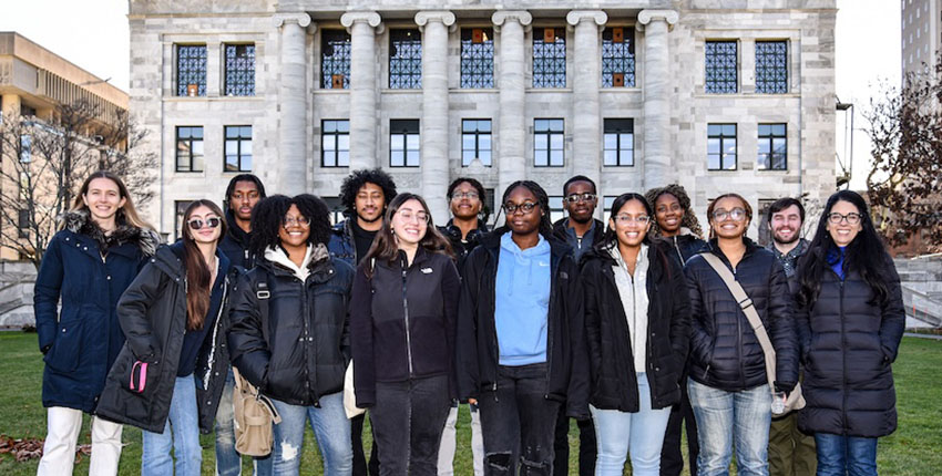 Group of high school students and instructors standing on the lawn in front of Gordon Hall