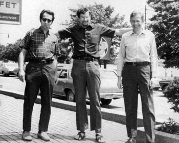 A black and white photo of three men standing side-by-side