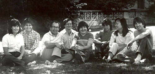 A black and white photo of Ed Kravitz and a group of 7 students sitting on the lawn