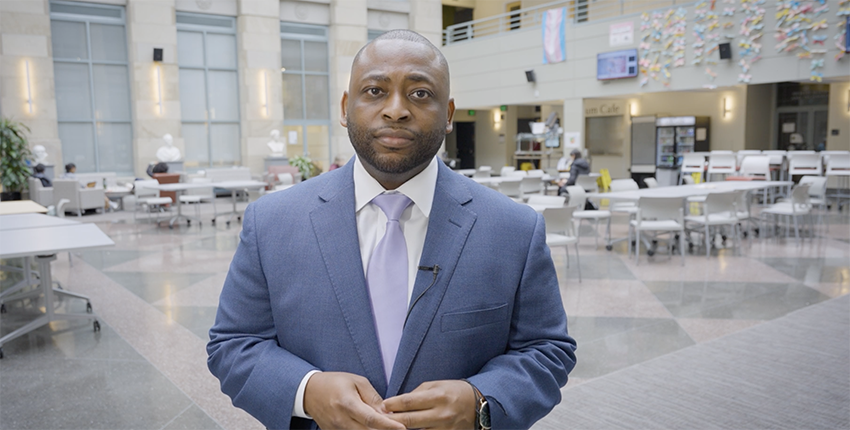 Moses Dixon in blue suit in TMEC Atrium