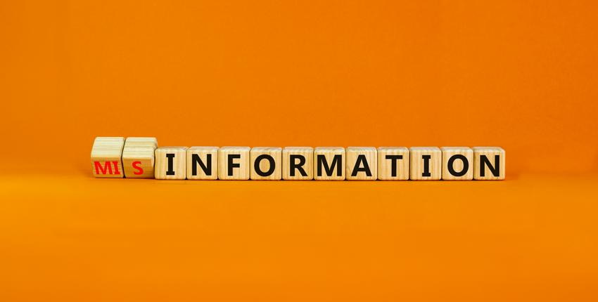 Children's blocks reading "misinformation" on an orange background