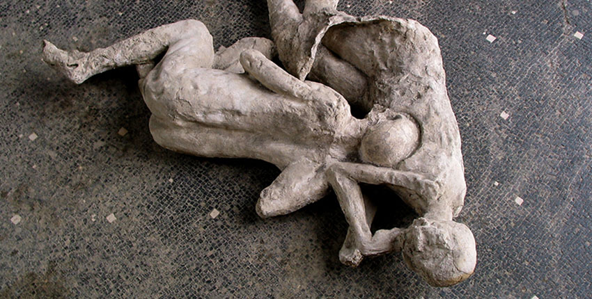 Plaster casts of two figures entangled on a tile floor