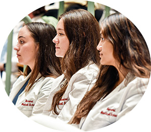 Photo of three women in white coats sitting