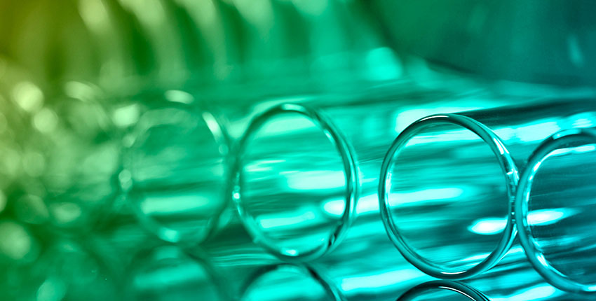 a closeup of test tubes lying on a table lit in green light
