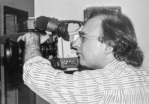 Black and white photo of a man focusing a camera