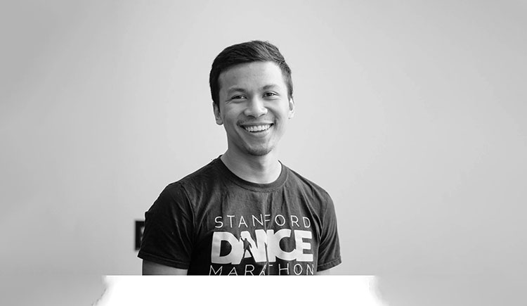 A man on a plain background smiles at the camera 