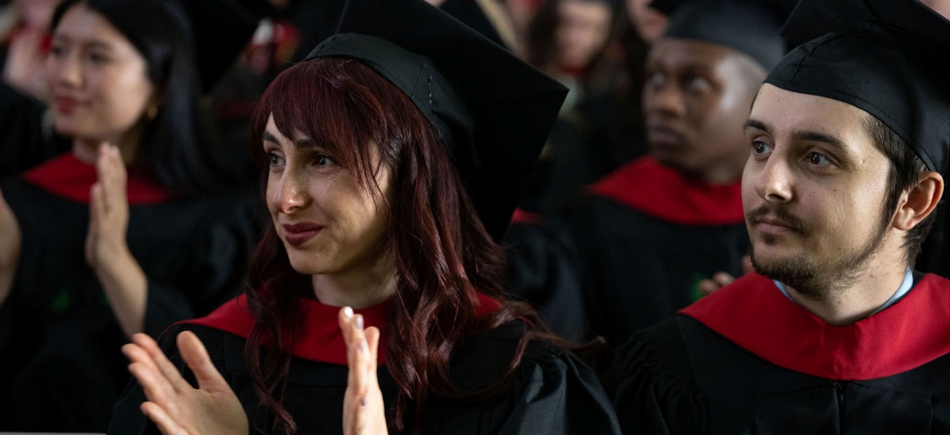 master's students in red and black graduation regalia