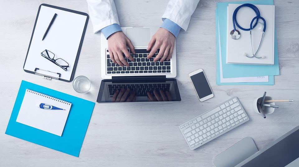 Medical professional typing on a compute.