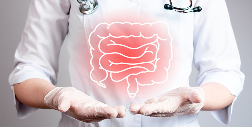 A human figure in a white coat, gloves, and stethoscope points to inflamed colon