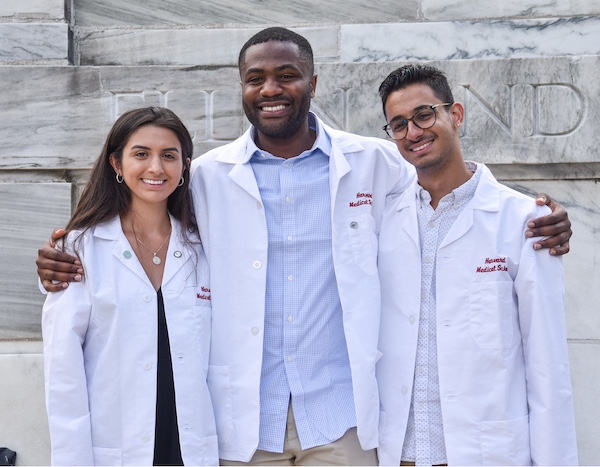 Three MD Student pose together in front of Gordon Hall.