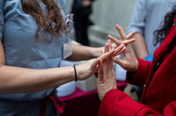 A close up of two students grasping each other's hands.